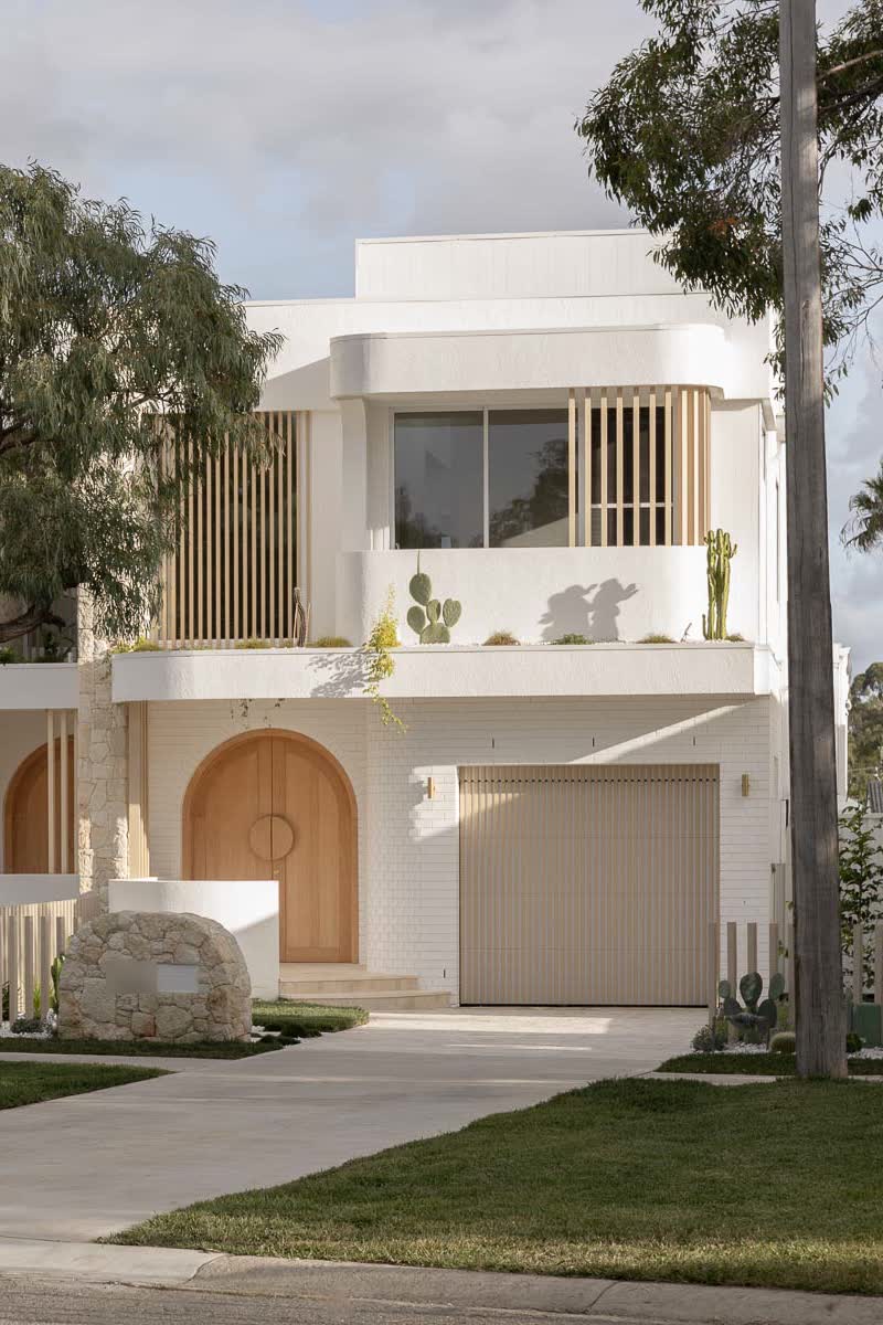 Street front of the white render and sandstone duplex